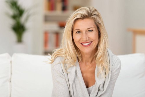 A blond, older woman smiles in a friendly way.