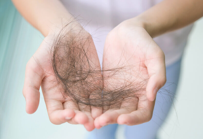 A person holds a bunch of hair in their hands.